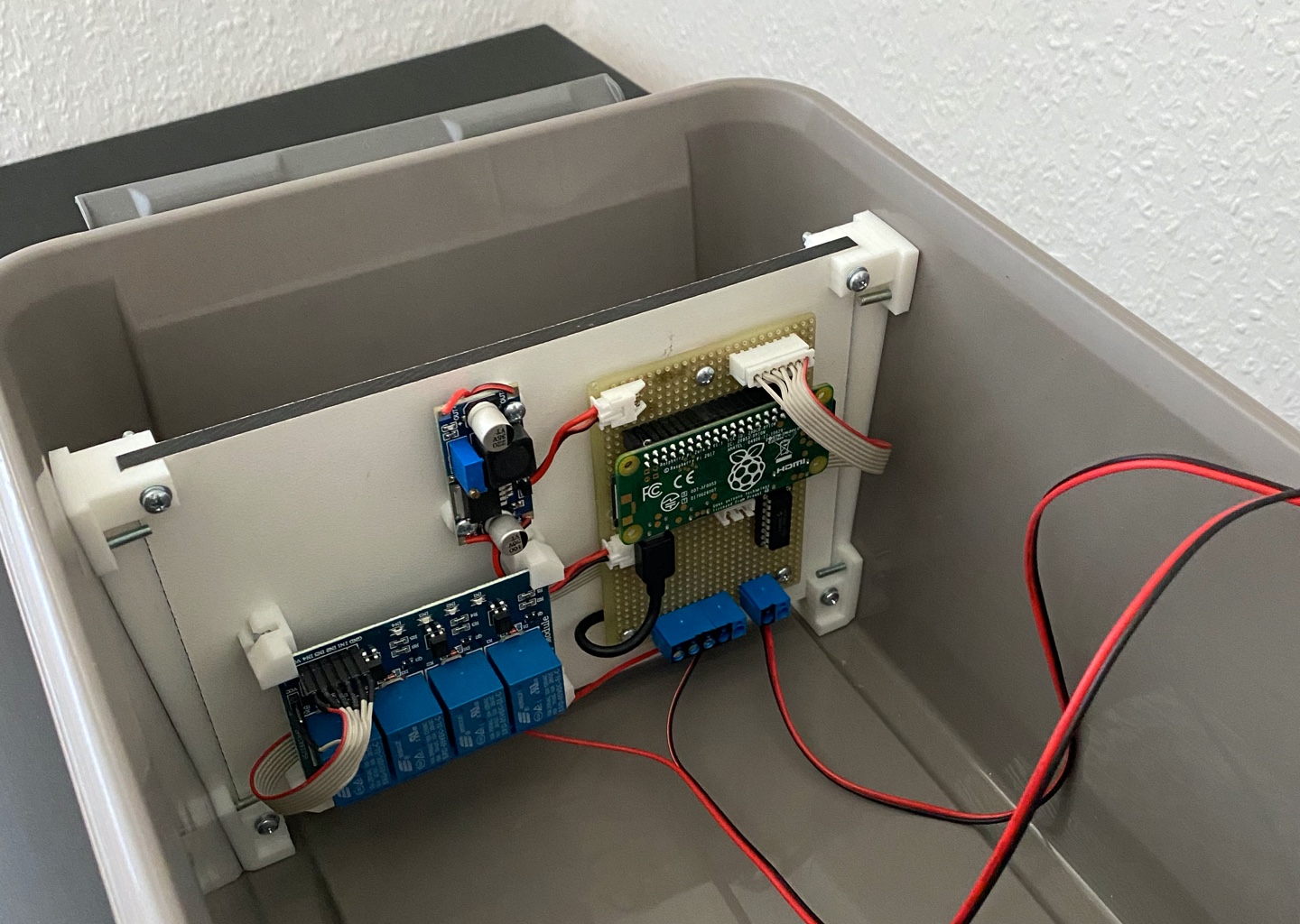 The plastic box that keeps the electronic components protected. One cable is used to deliver power to the system, the other one is used to control the pump.